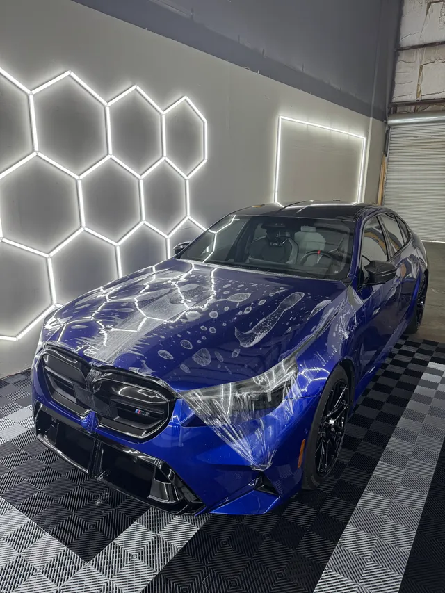 Blue BMW SUV coupe having paint protection film fitted to the hood and front bumper in Alpharetta, GA